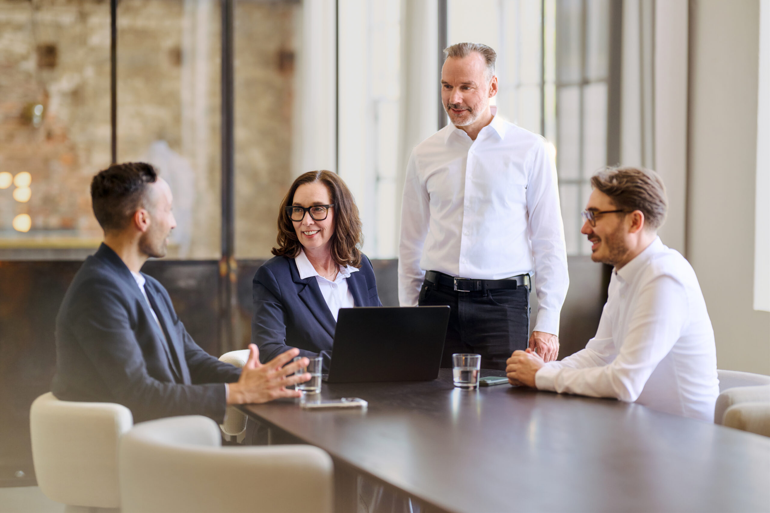 Mitarbeiter sitzend und stehend am Tisch